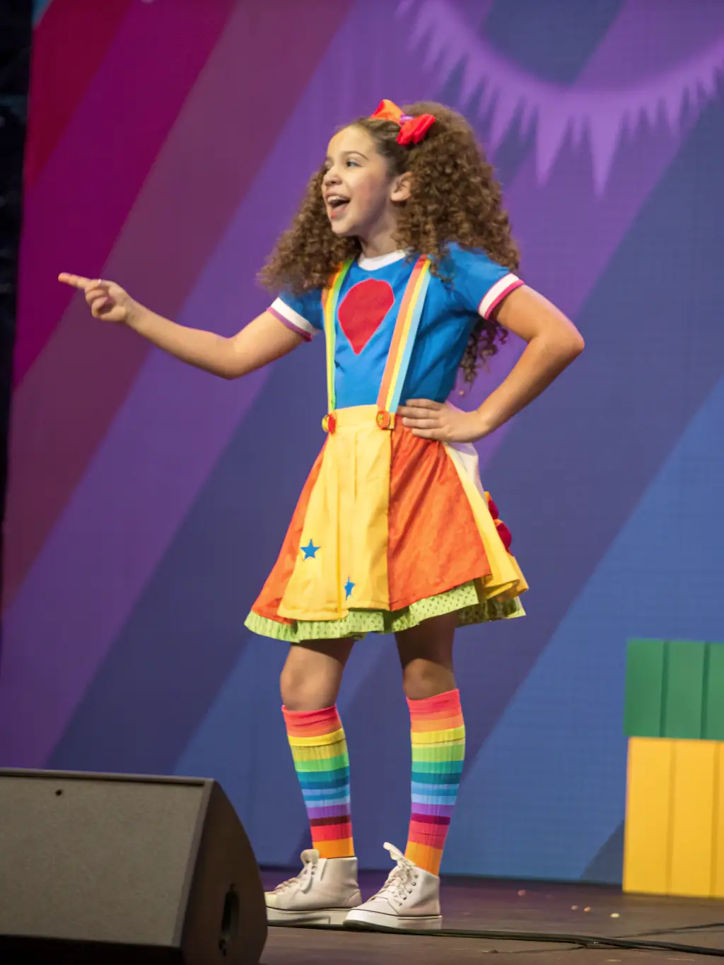 A heartwarming image of a child confidently performing on stage during a L'ANE A AILES COMPAGNIE production, radiating joy and accomplishment.